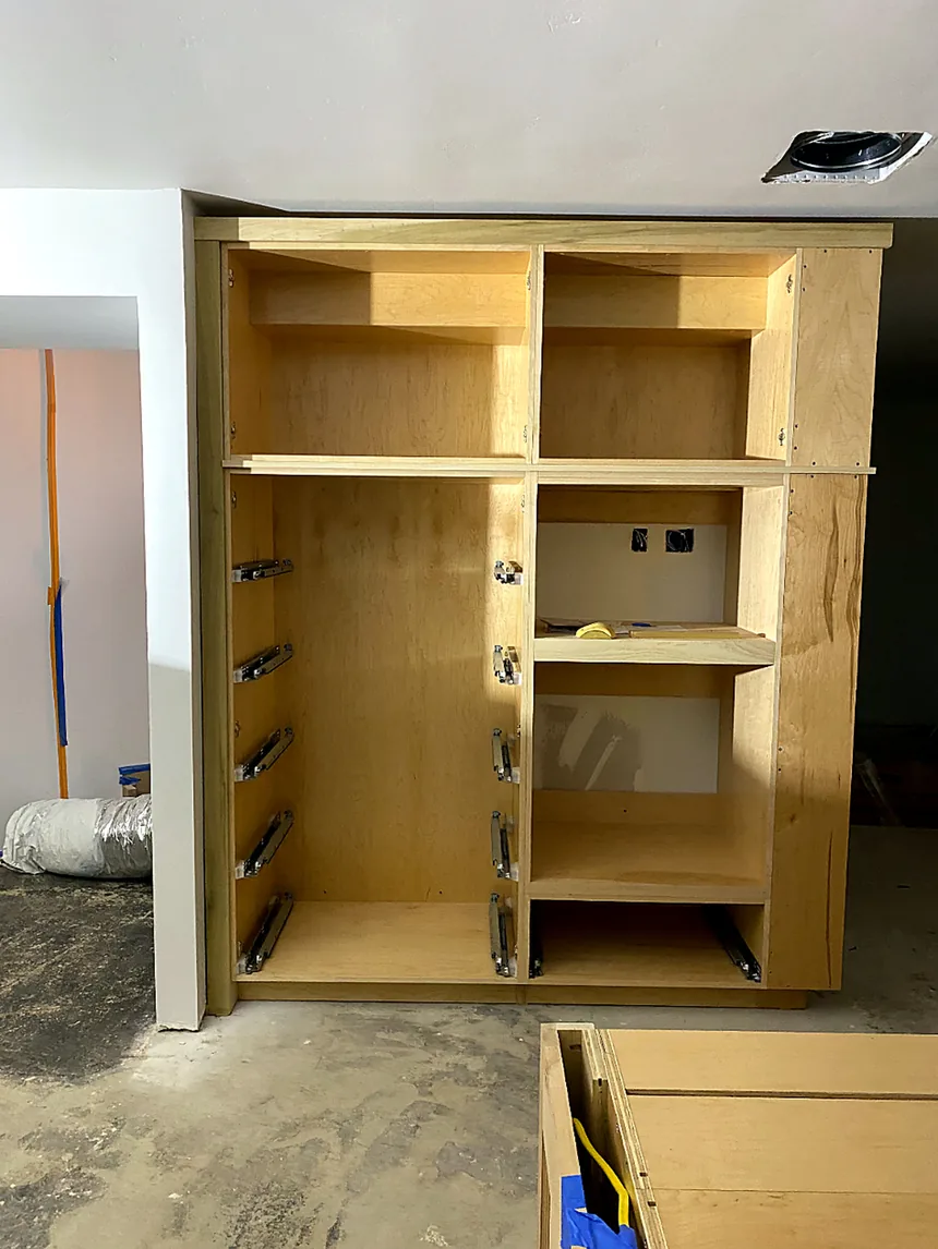 Unfinished kitchen cabinet boxes installed with soft-close drawer slides during a kitchen build