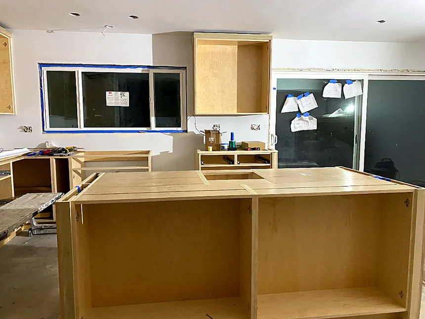 Kitchen island cabinetry under construction with plumbing rough-in visible