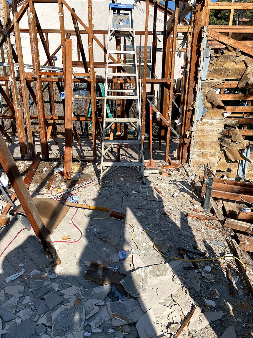 New wood wall framing, ladder and job site tools on a residential construction site