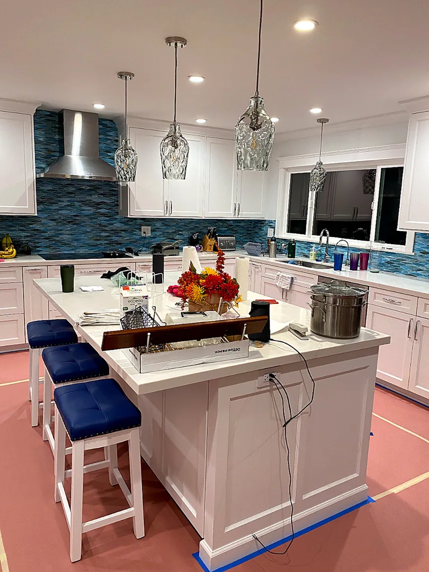 Completed kitchen with white cabinetry and a glass tile backsplash